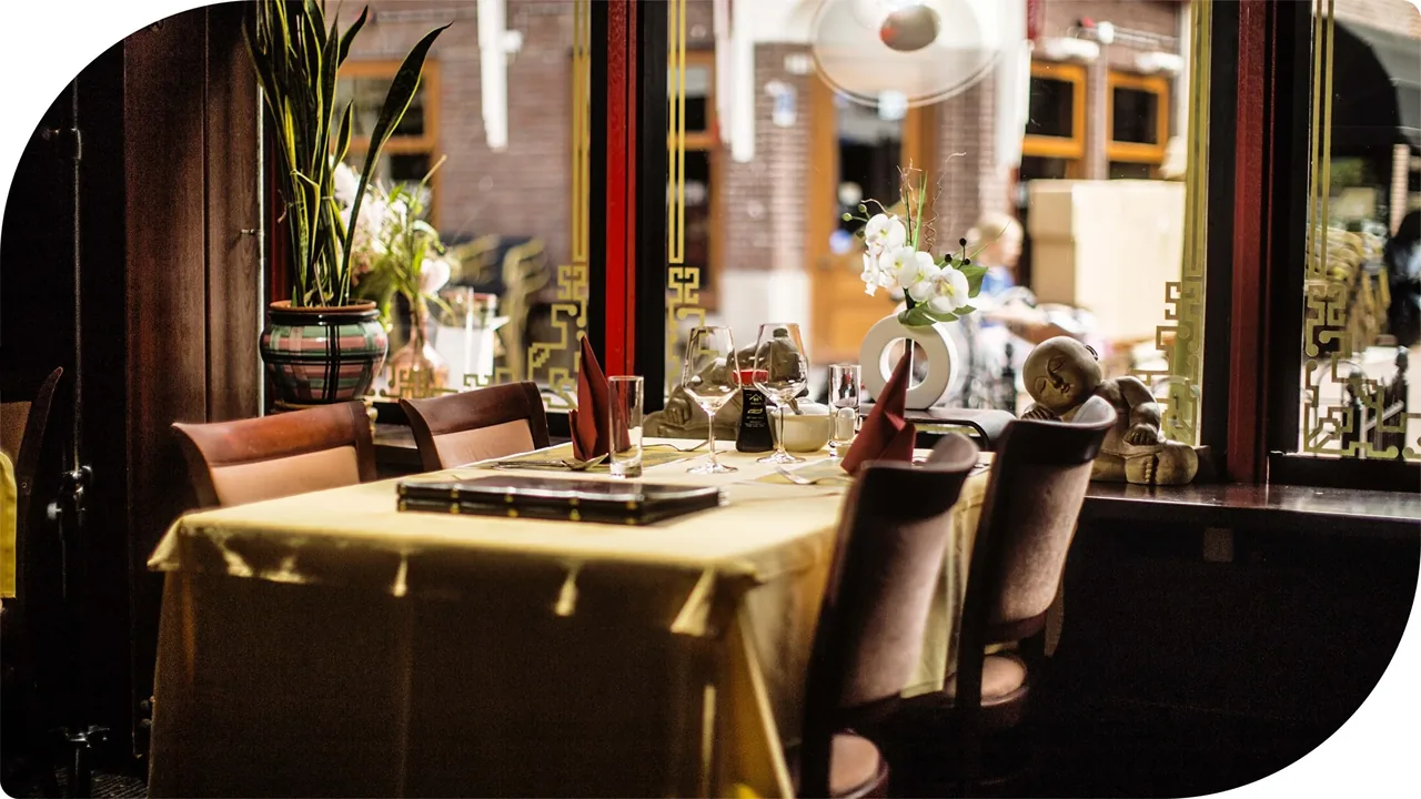 Binnen: een gedekte tafel bij het raam – Royal San Kong