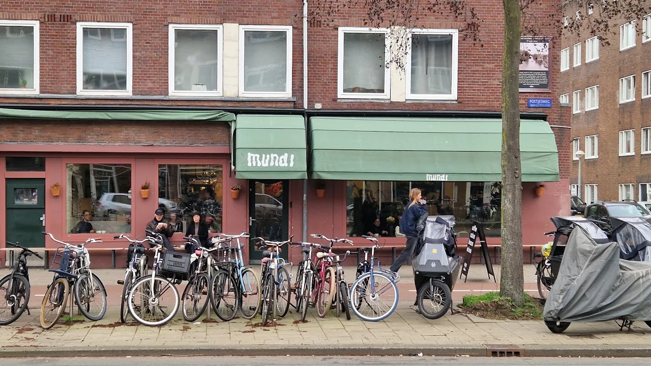 De gevel met groene luifels aan de Postjesweg – Mundi