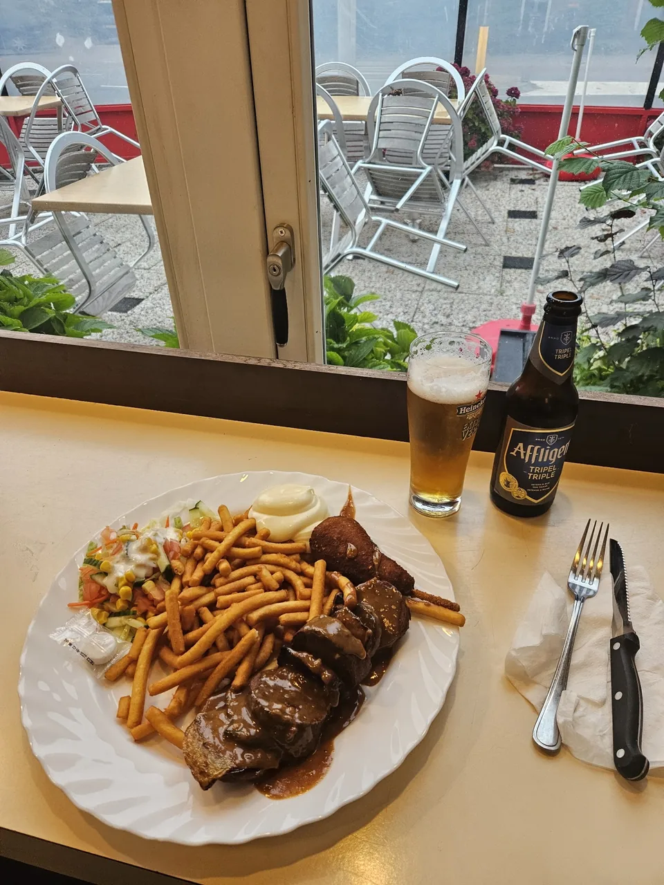 Binnen aan het raam, met zicht op het terras – Cafetaria De Dalton