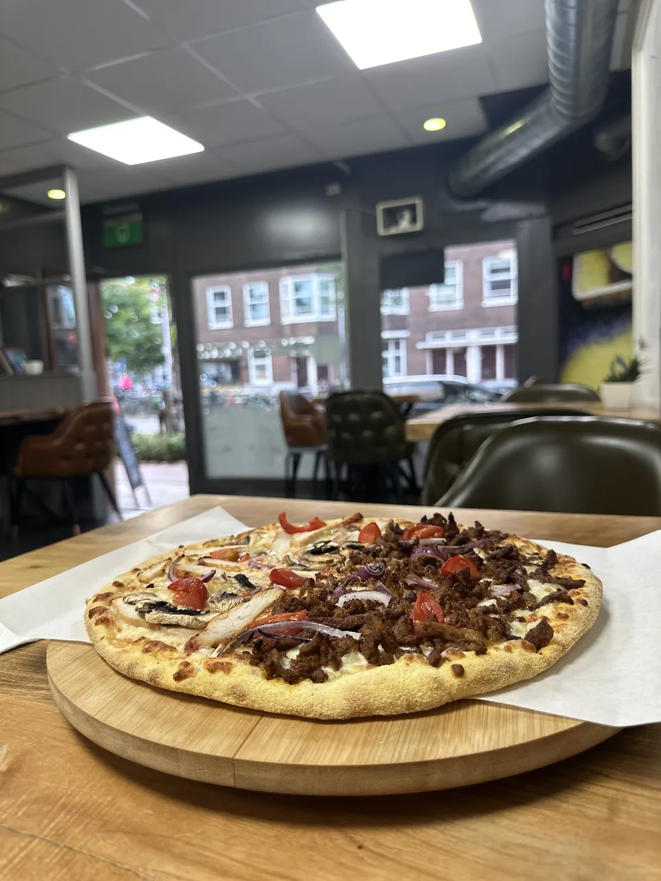 Pizza aan tafel bij het raam – Pizzadam Amsterdam Zuid