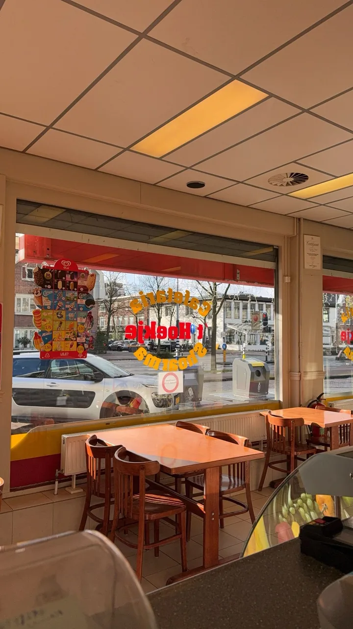 Binnen: tafels aan het raam – Cafetaria 't Hoekje